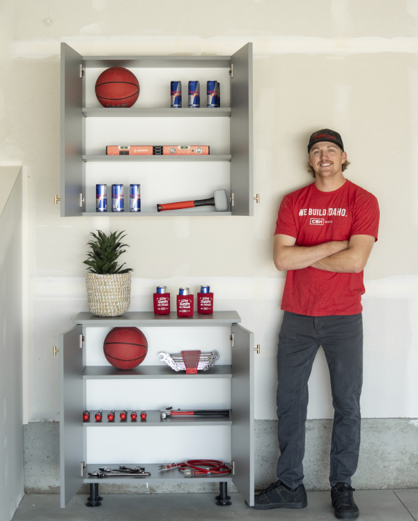 Man standing by garage cabinets with arms crossed