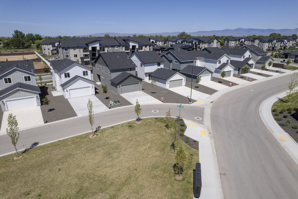 Aerial image of multiple new CBH homes with large front driveways, facing a small green space and intersecting corner streets, creating a clean and well-spaced neighborhood layout.