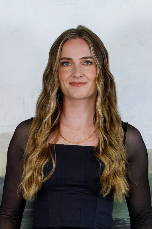 Professional headshot of Cassidy Seamons, Listing Coordinator at CBH Homes, smiling with long highlighted hair in a clean, professional setting