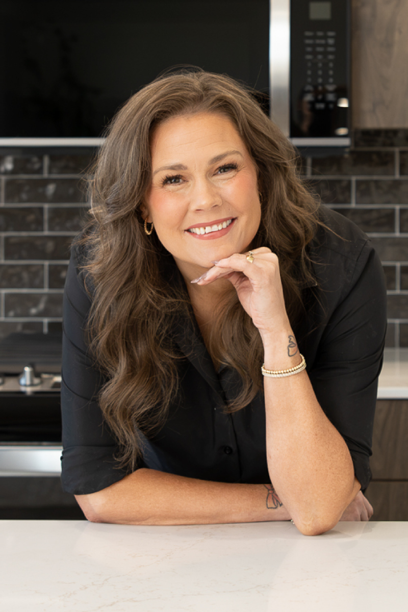 Professional headshot of Chelsea Nielsen, CBH Homes sales specialist, smiling inside a modern model home.
