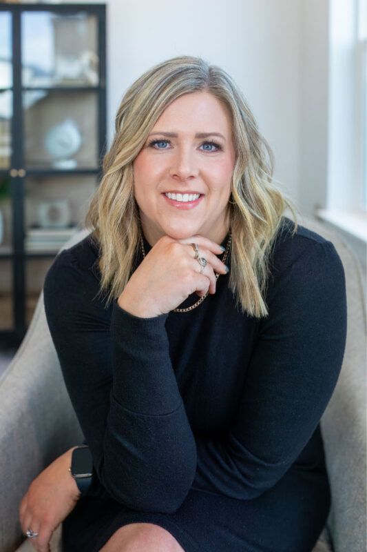 Professional headshot of Lonneka Nagle, an agent at CBH Homes, smiling with blonde hair in a stylish indoor setting with soft natural lighting
