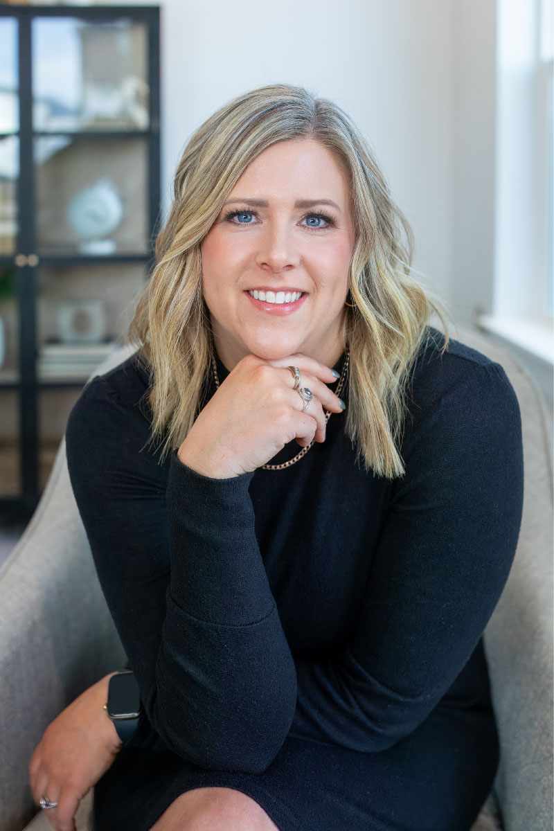 Professional headshot of Lonneka Nagle, an agent at CBH Homes, smiling with blonde hair in a stylish indoor setting with soft natural lighting