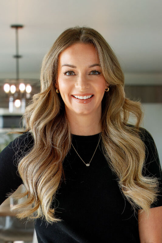 Megan Luther, listing agent at CBH Homes, smiling and wearing a black shirt
