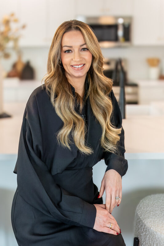 Megan Luther, listing agent at CBH Homes, smiling and wearing a black shirt