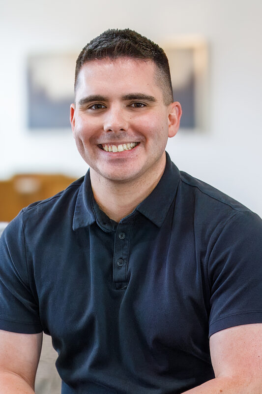 Troy Parquer, transaction coordinator at CBH Homes, smiling and wearing a black shirt