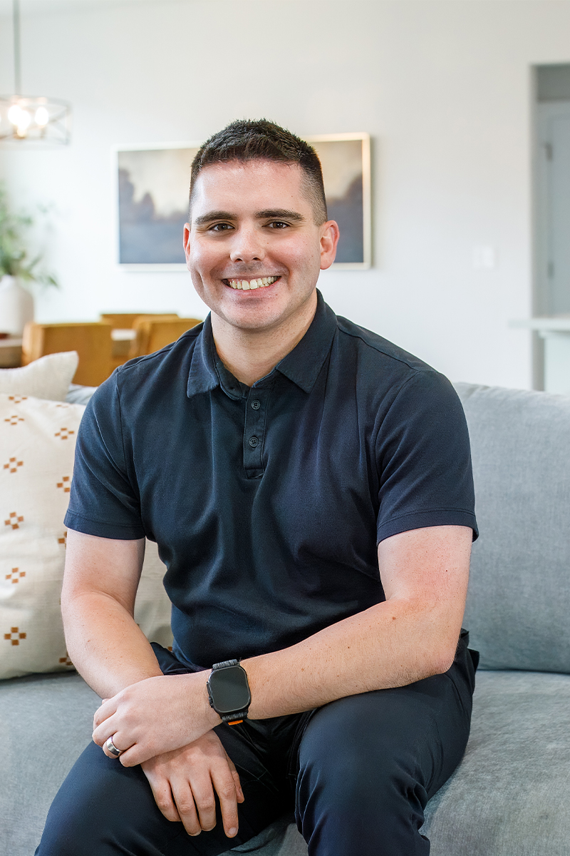 Troy Parquer, transaction coordinator at CBH Homes, smiling and wearing a black shirt