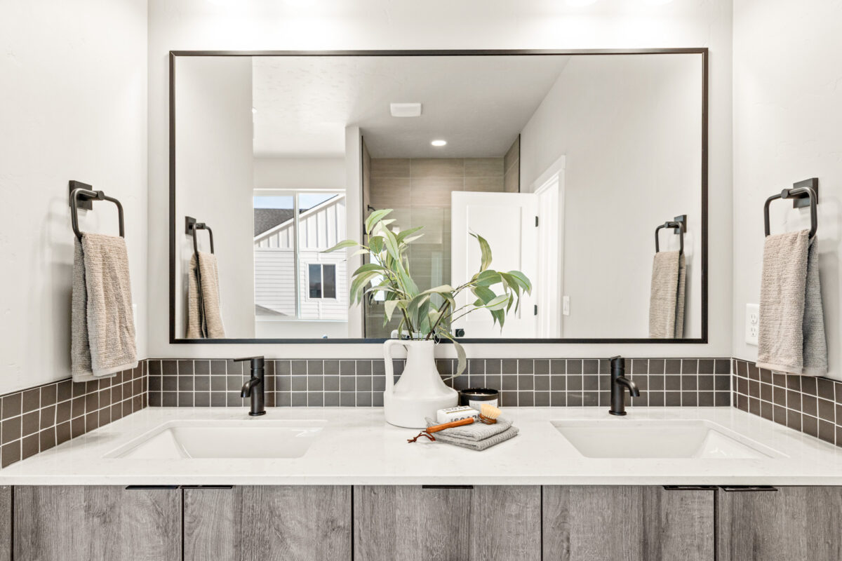 Modern bathroom vanity with large mirror and contemporary lighting in a new CBH Homes home in Beaconwood, Eagle, Idaho