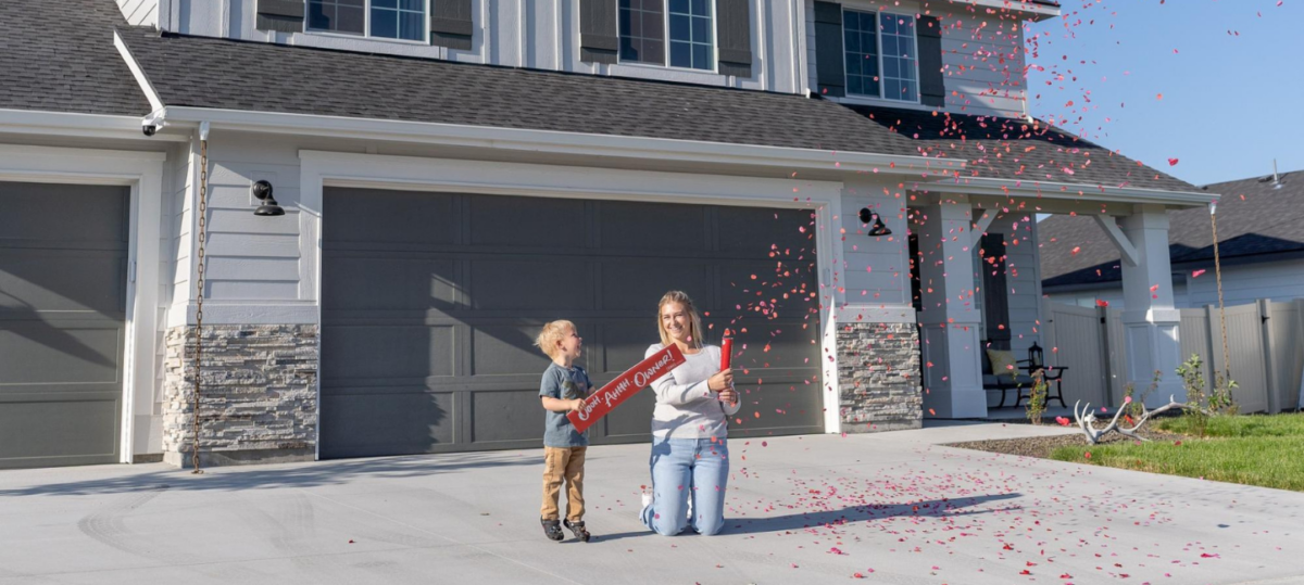 Happy new homeowners celebrating with red confetti in front of their new CBH home in Meridian, Idaho.