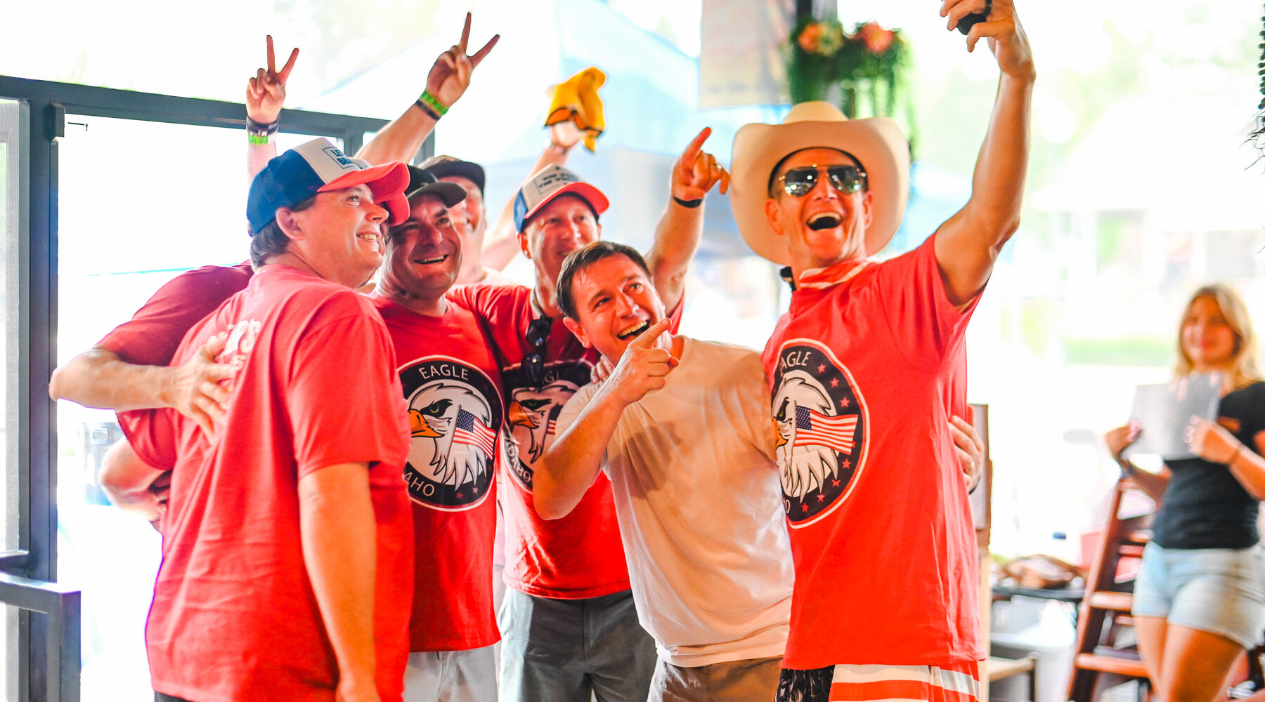 Group of men in red Eagle, Idaho shirts taking a celebratory selfie at Spitfire during Eagle Fun Days event