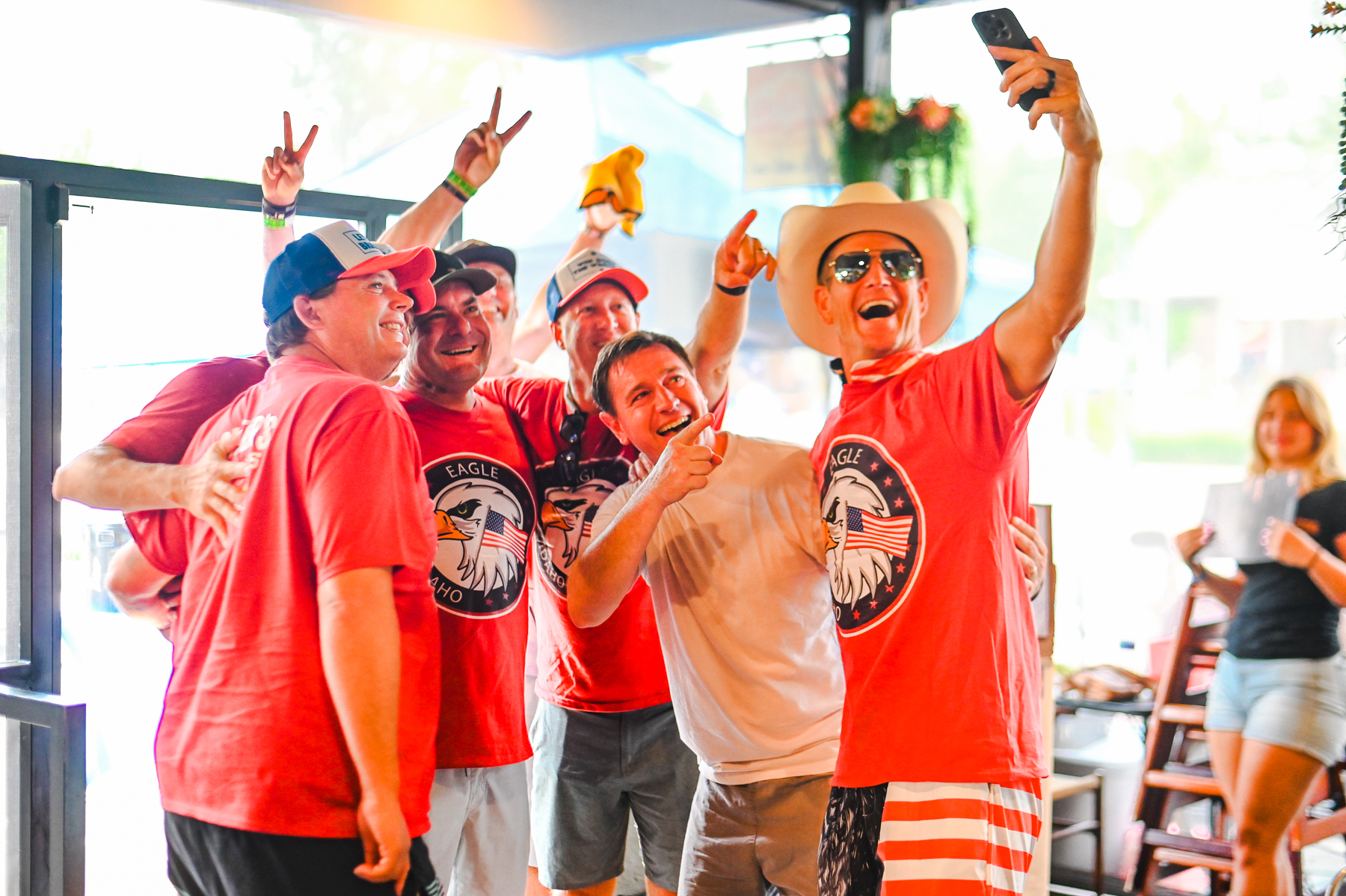 Group of men in red Eagle, Idaho shirts taking a celebratory selfie at Spitfire during Eagle Fun Days event