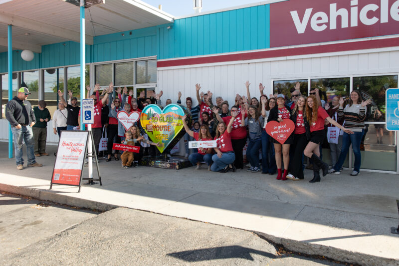 smiling people standing around a heart unveiling