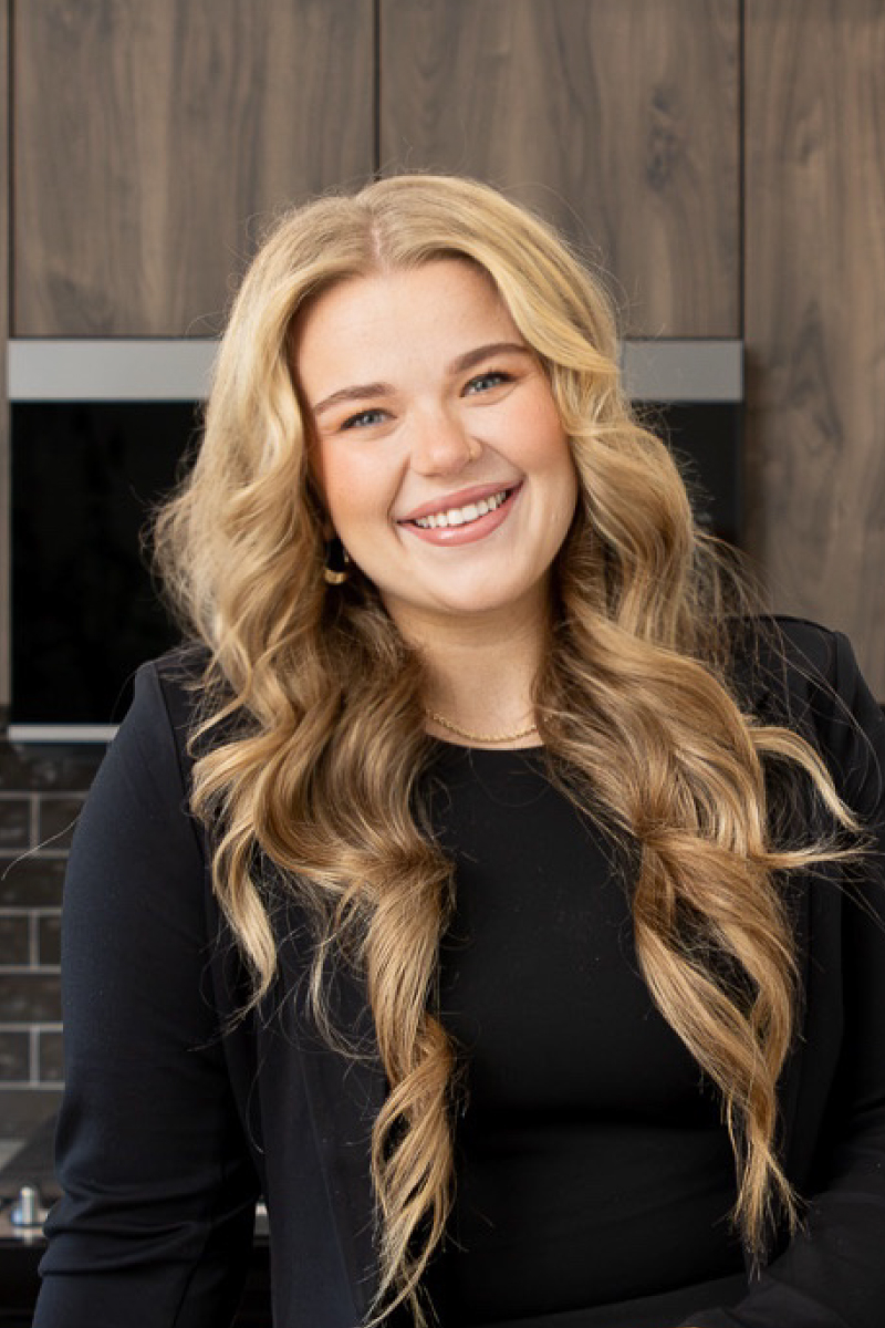 Professional headshot of Cassidy Ridgway, CBH Homes sales professional, smiling in a modern model home.