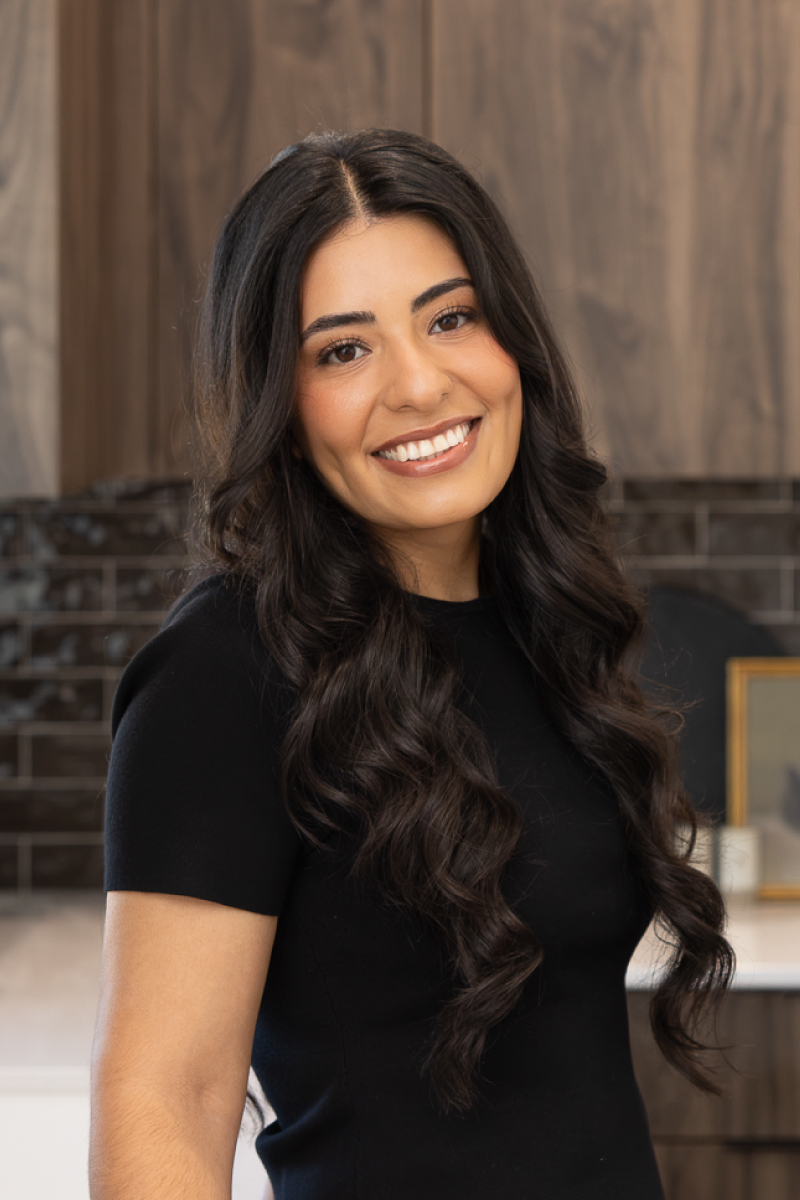 Professional headshot of Jacky Brindle, CBH Homes sales specialist, smiling inside a beautifully designed model home.