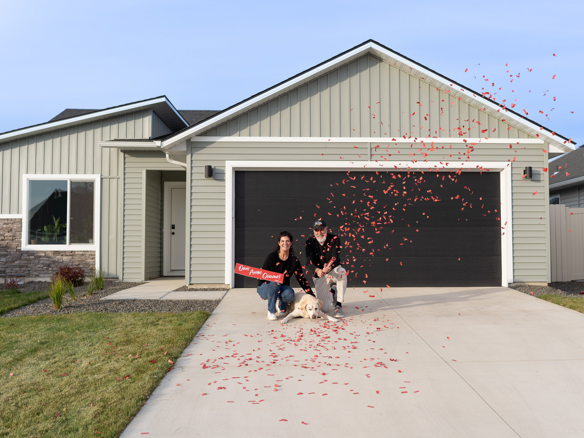 CBH Homes homeowners celebrating in front of their new house with confetti and a sold sign