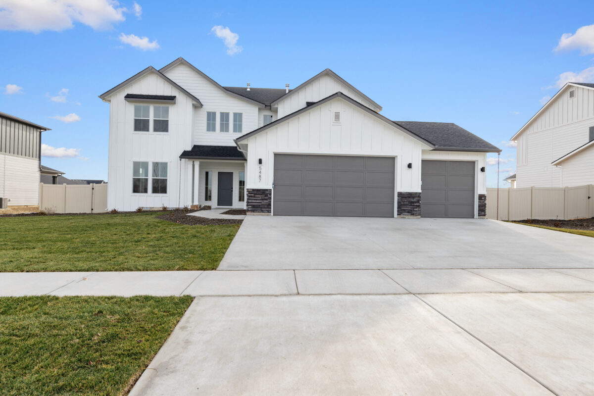 Modern two-story CBH Homes Milano floor plan in Beaconwood featuring white farmhouse exterior, dark trim, stone accents, and a three-car garage.
