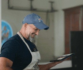 Artist Mark Houston smiling looking at his artwork