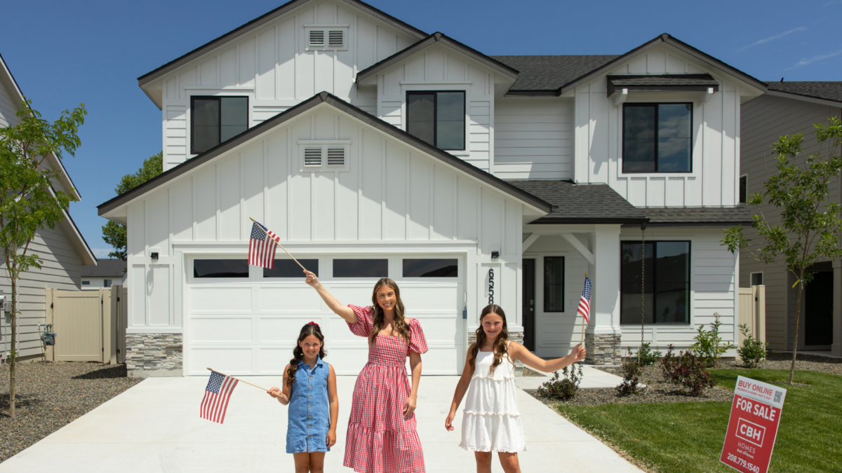 Family waving American flags outside a new CBH Homes property, part of CBH's Fourth of July home sale event.