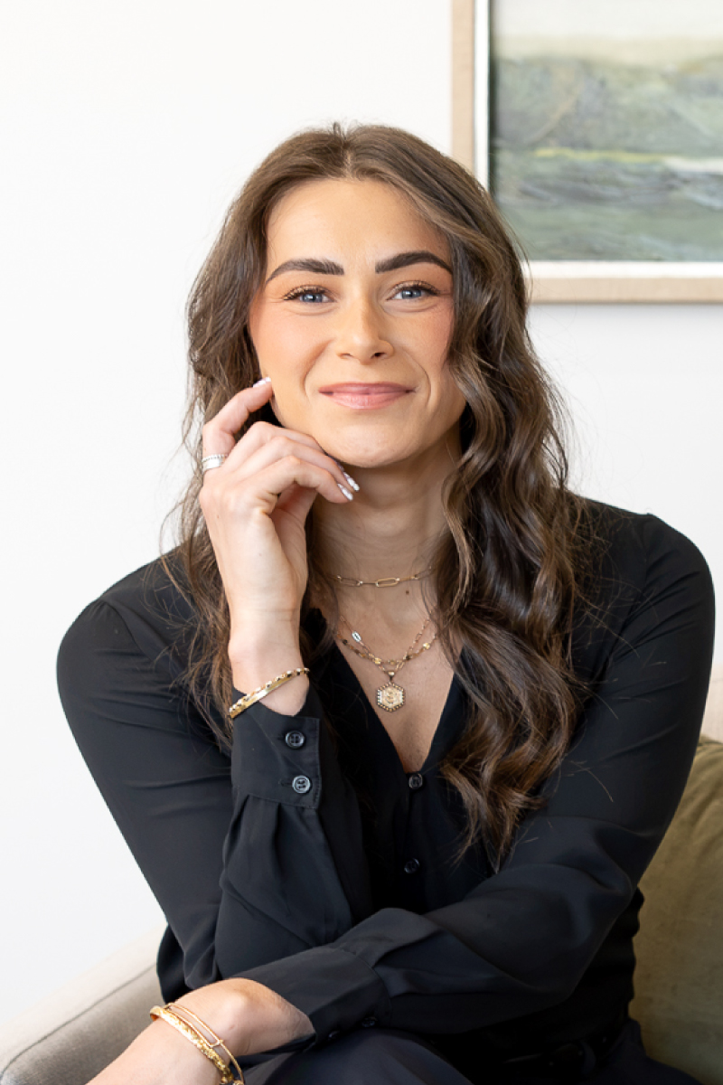 Professional headshot of Sophie Confalone, CBH Homes sales professional, smiling in a modern office setting.